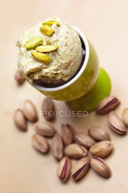 Vista de primer plano de helado en taza de huevo con pistachos - foto de stock