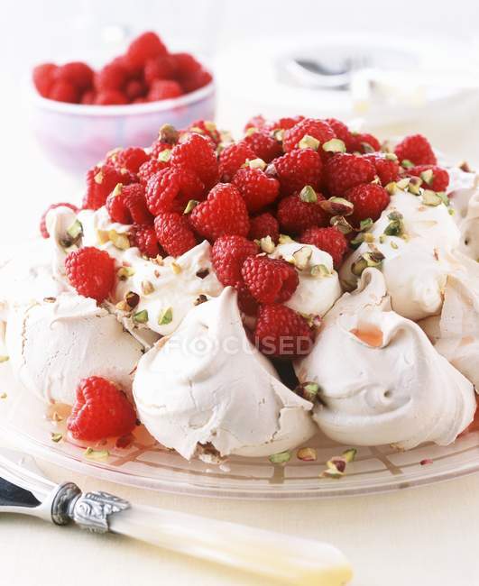 Closeup view of Pavlova topped with whipped cream, raspberries and powdered sugar — Stock Photo
