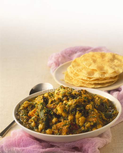 Curry vegetal com grão de bico e pão achatado na placa branca — Fotografia de Stock