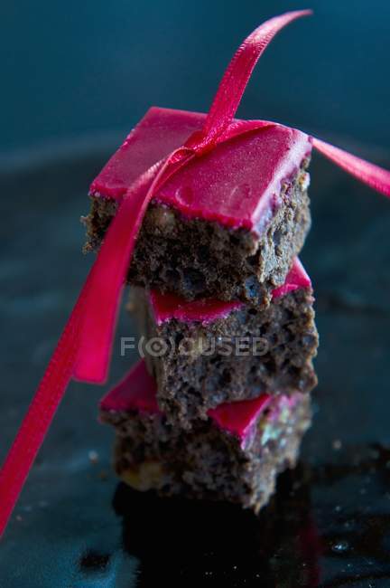 Servir des brownies décorés avec du glaçage rouge — Photo de stock