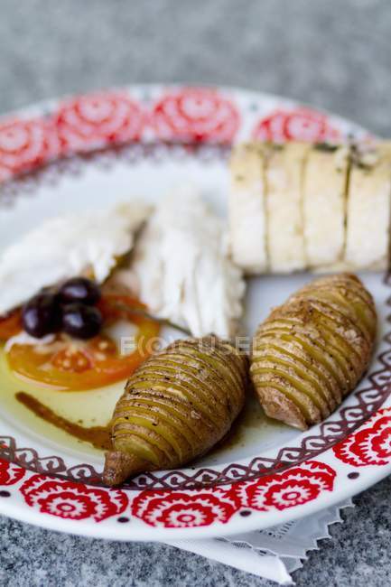 A plate of starters with Hasselback potatoes — Stock Photo