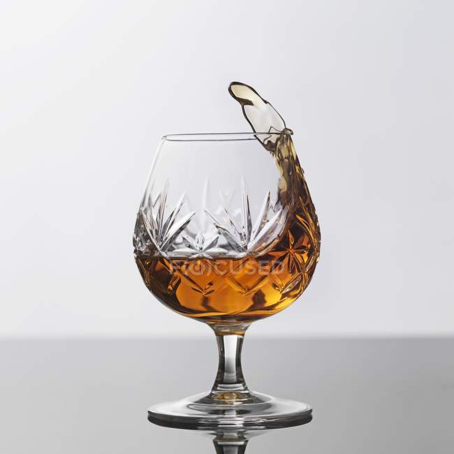 Vista de close-up de Brandy splash em vidro — Fotografia de Stock