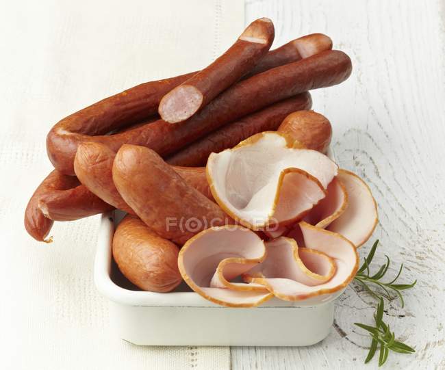 Sausages and sliced ham — Stock Photo