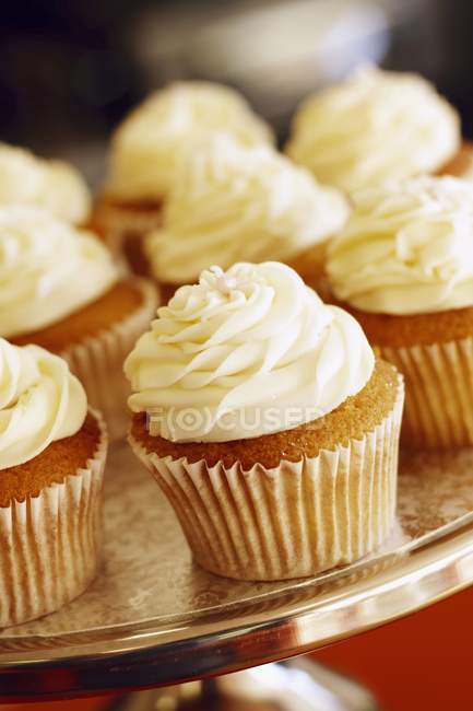Crema de mantequilla cupcakes en pie de pastel - foto de stock