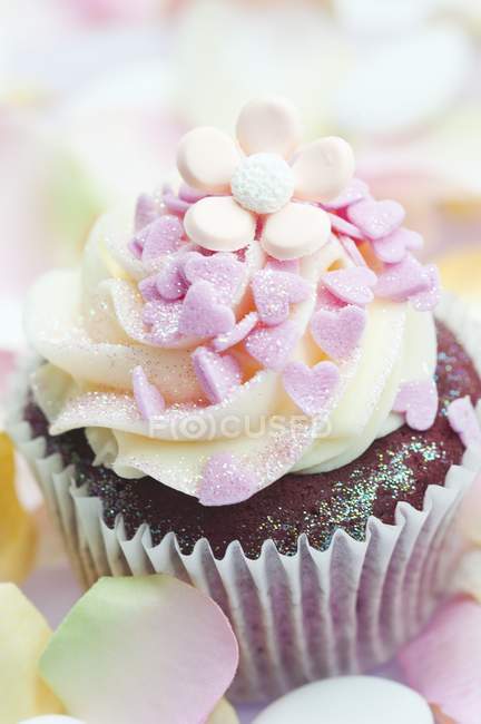 Cupcake decorated with pink sugar hearts — Stock Photo