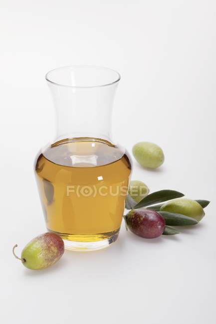 Olio in brocca e olive fresche — Foto stock