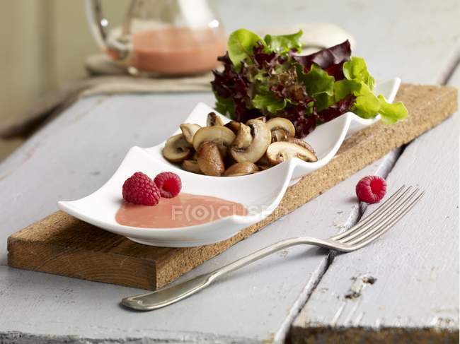 Closeup view of green salad with fried mushrooms and raspberry dressing — Stock Photo