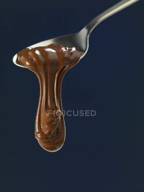 Melted Chocolate flowing from spoon — Stock Photo