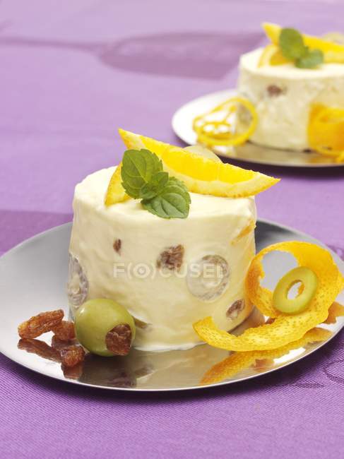 Orange parfait with olives on plate over purple surface — Stock Photo