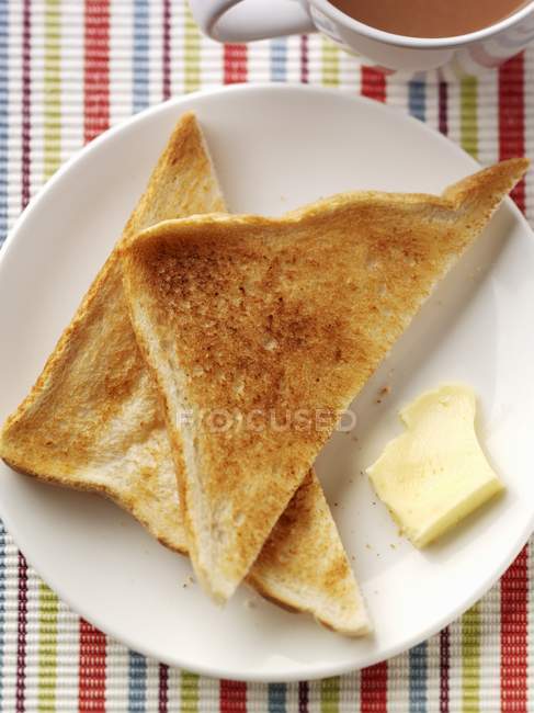 Vue rapprochée du dessus des toasts au beurre et au thé — Photo de stock