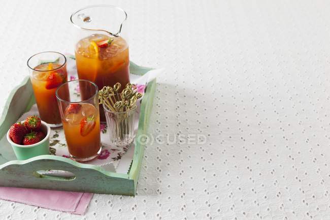 Closeup view of drinks with strawberries and oranges on a tray — Stock Photo