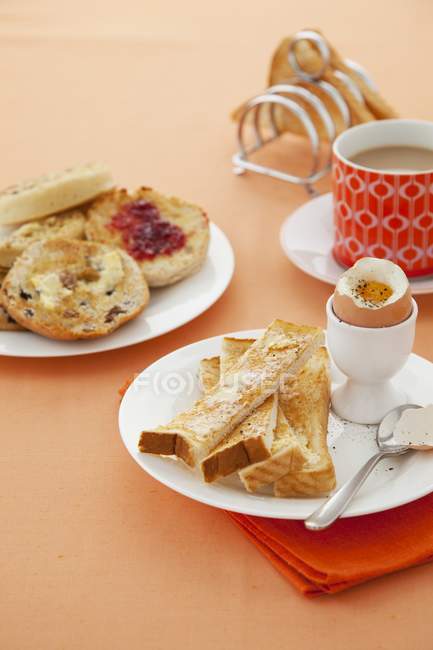 Vista de primer plano del desayuno con el huevo cocido, tostadas y té - foto de stock