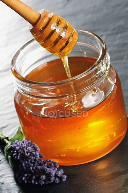 Jar of honey with spoon — Stock Photo
