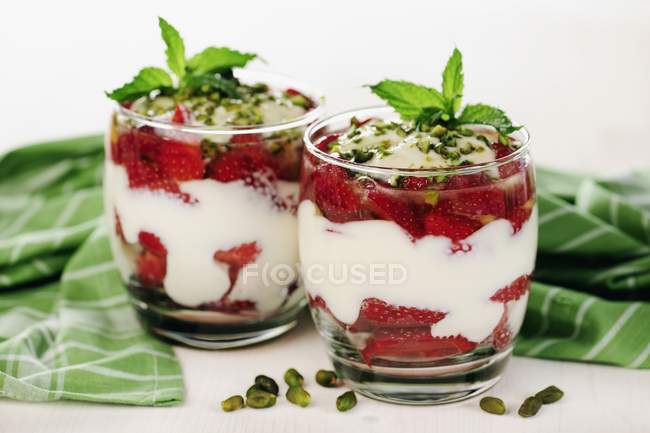 Vue rapprochée du yaourt grec aux fraises et aux pistaches — Photo de stock