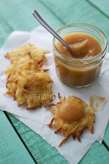 Potato rstis with apple puree  over wooden surface with napkin — Stock Photo