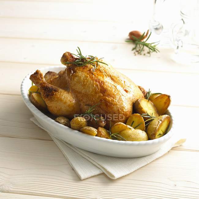Whole Rosemary chicken with potatoes — Stock Photo