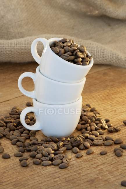 Tazas blancas y granos de café - foto de stock