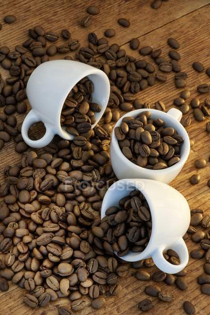 Granos de café y tazas de café expreso - foto de stock