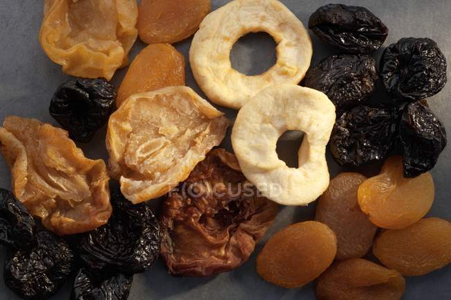 A variety of dried fruit over grey surface — Stock Photo
