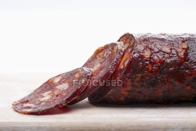 Sliced salami on wooden board — Stock Photo