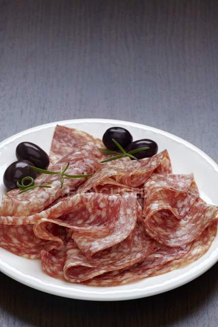 Scheiben Salami mit Oliven — Stockfoto