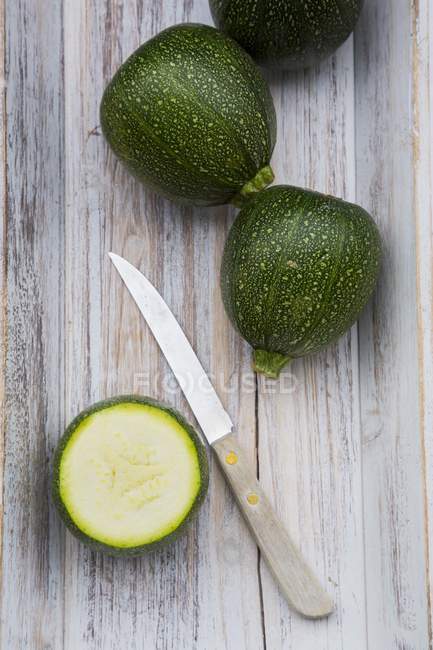 Round courgettes with slice and knife — Stock Photo