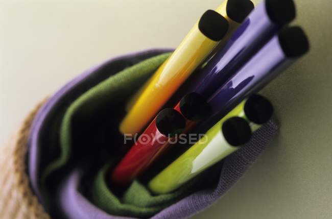 Baguettes colorées enveloppées dans des serviettes vertes et violettes — Photo de stock