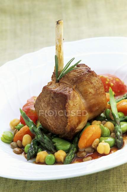 Saddle of lamb on bed of vegetables — Stock Photo