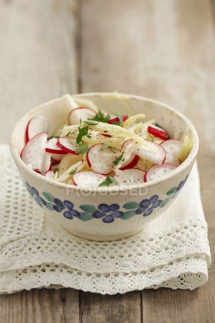 Coleslaw with radishes in bowls over towel  over wooden surface — Stock Photo