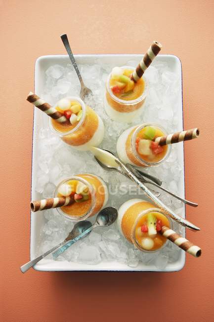 Iced melon yogurt in white dish over orange surface — Stock Photo