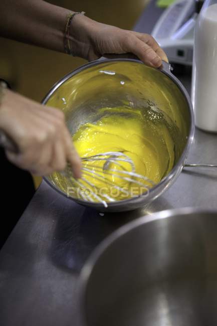Mãos batendo gema de ovo de ovo e açúcar — Fotografia de Stock