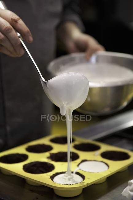 Batter being poured into a muffin tin — Stock Photo