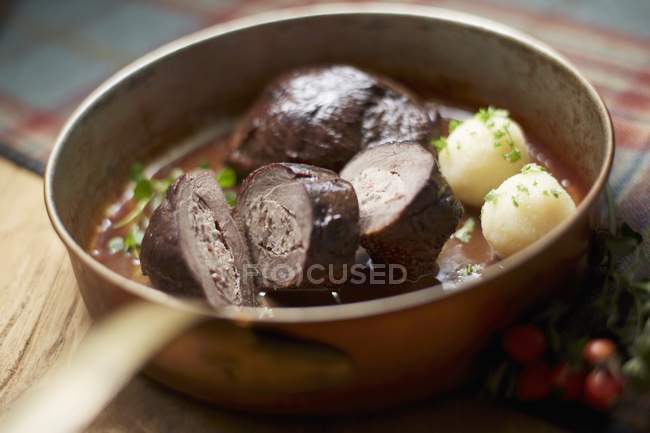 Closeup view of goose breast with mini dumplings and herb in pan — Stock Photo