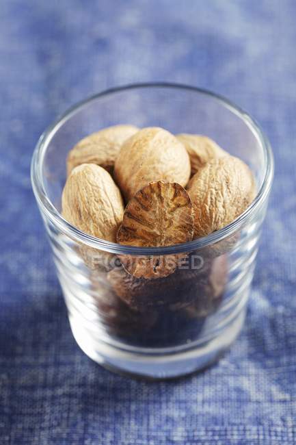 Whole Nutmegs in glass — Stock Photo