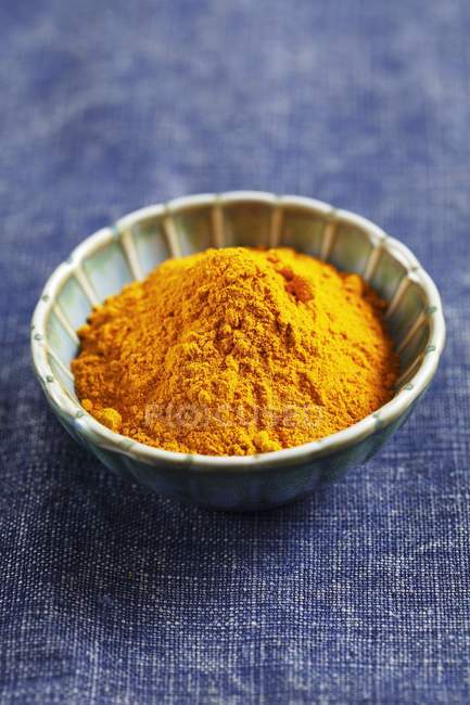Ground turmeric in small bowl — Stock Photo