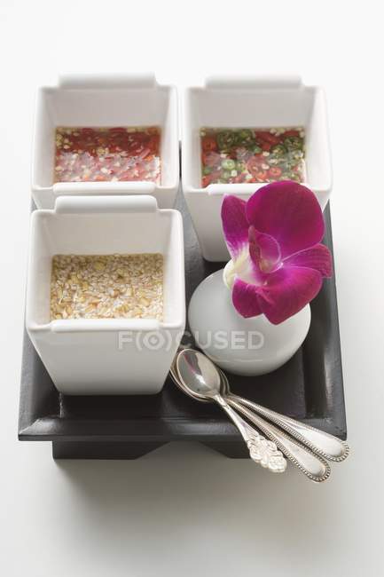 Três molhos asiáticos picantes na bandeja no fundo branco — Fotografia de Stock