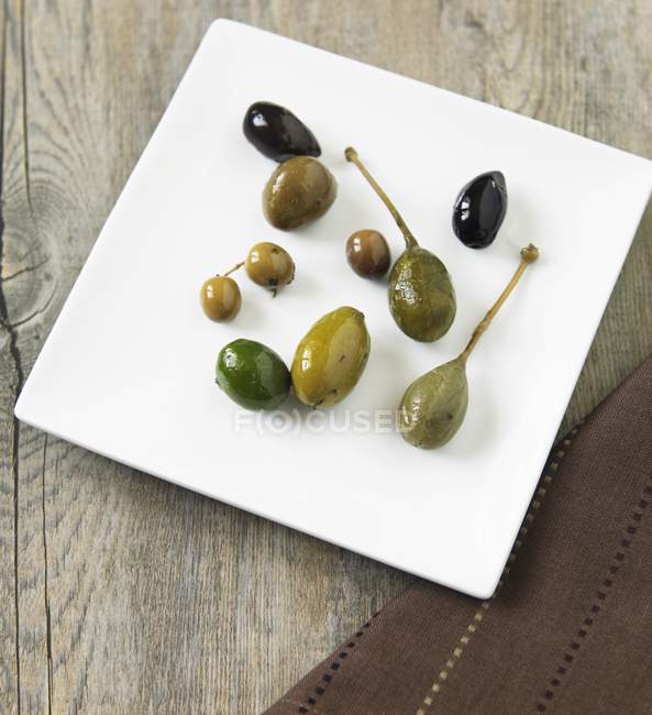 Оливки на белом блюде — стоковое фото
