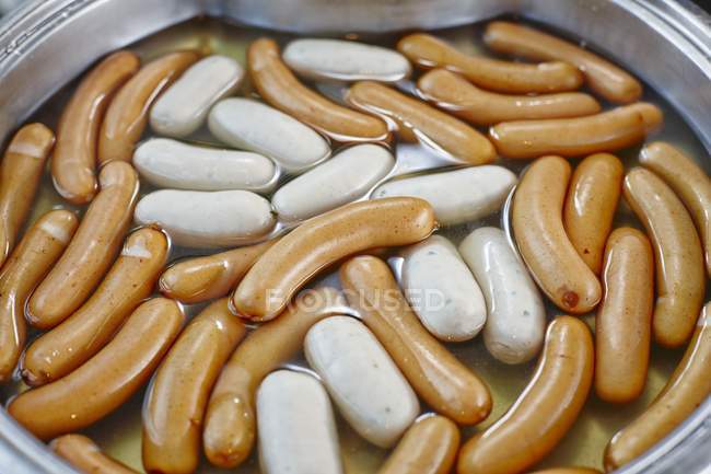 Sausages in pot with water — Stock Photo