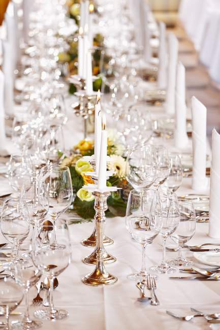 Uma mesa festivamente decorada com copos de vinho e castiçais — Fotografia de Stock