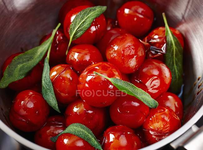 Cherry tomatoes with sage in metal pot — Stock Photo