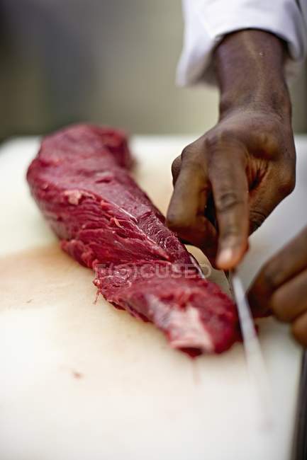 Chef removing fat from beef — Stock Photo
