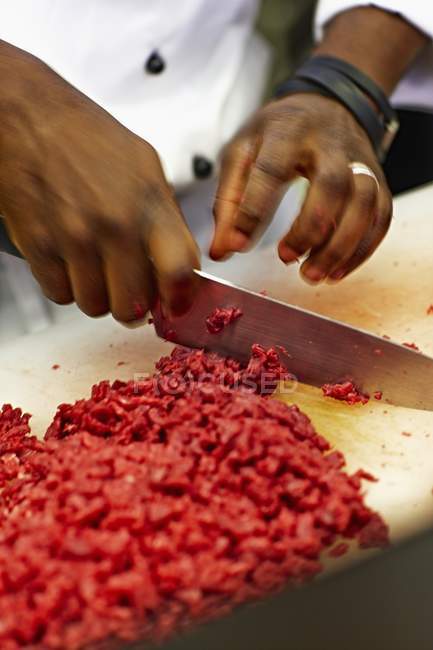 Шеф-кухар подрібнює сиру яловичину — стокове фото