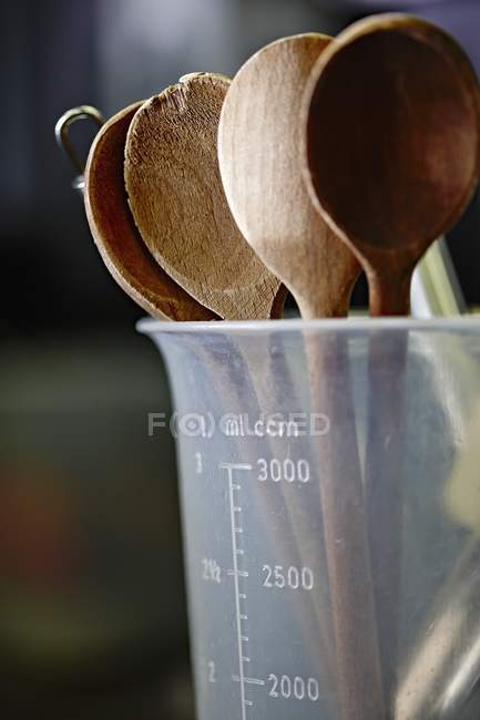 Vista de perto de colheres de madeira em um jarro de medição — Fotografia de Stock