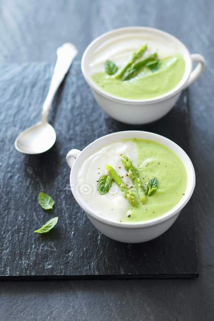 Cream of asparagus soup with peas — Stock Photo