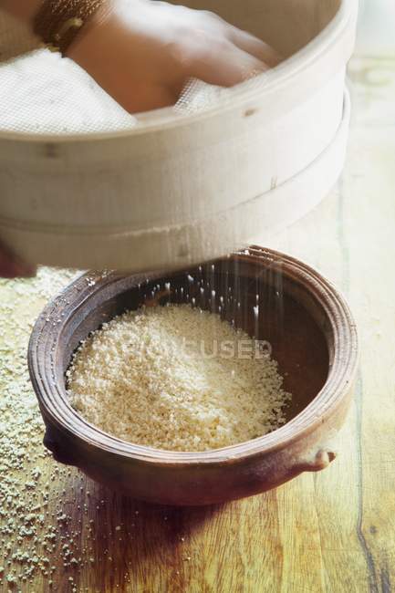 Couscous being sieved — Stock Photo