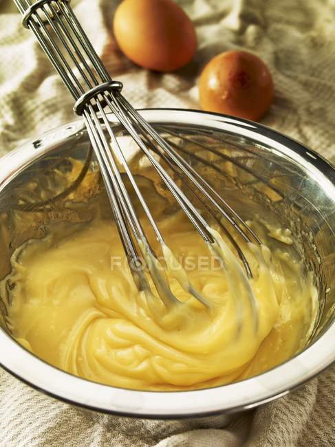 Vista close-up de maionese batida com um batedor em uma tigela de mistura — Fotografia de Stock