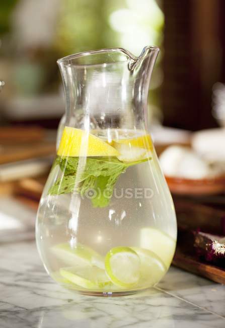 Closeup view of water with lemon in jug — Stock Photo