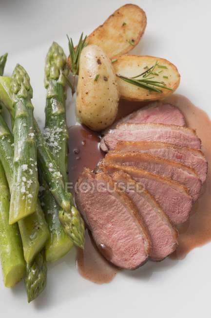 Sliced Duck breast with green asparagus — Stock Photo
