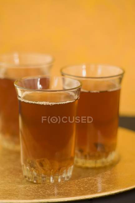 Três copos de chá preto — Fotografia de Stock