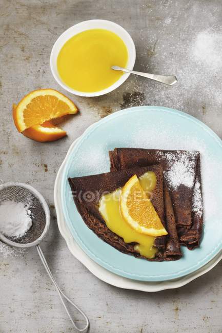 Chocolate pancakes with orange sauce — Stock Photo